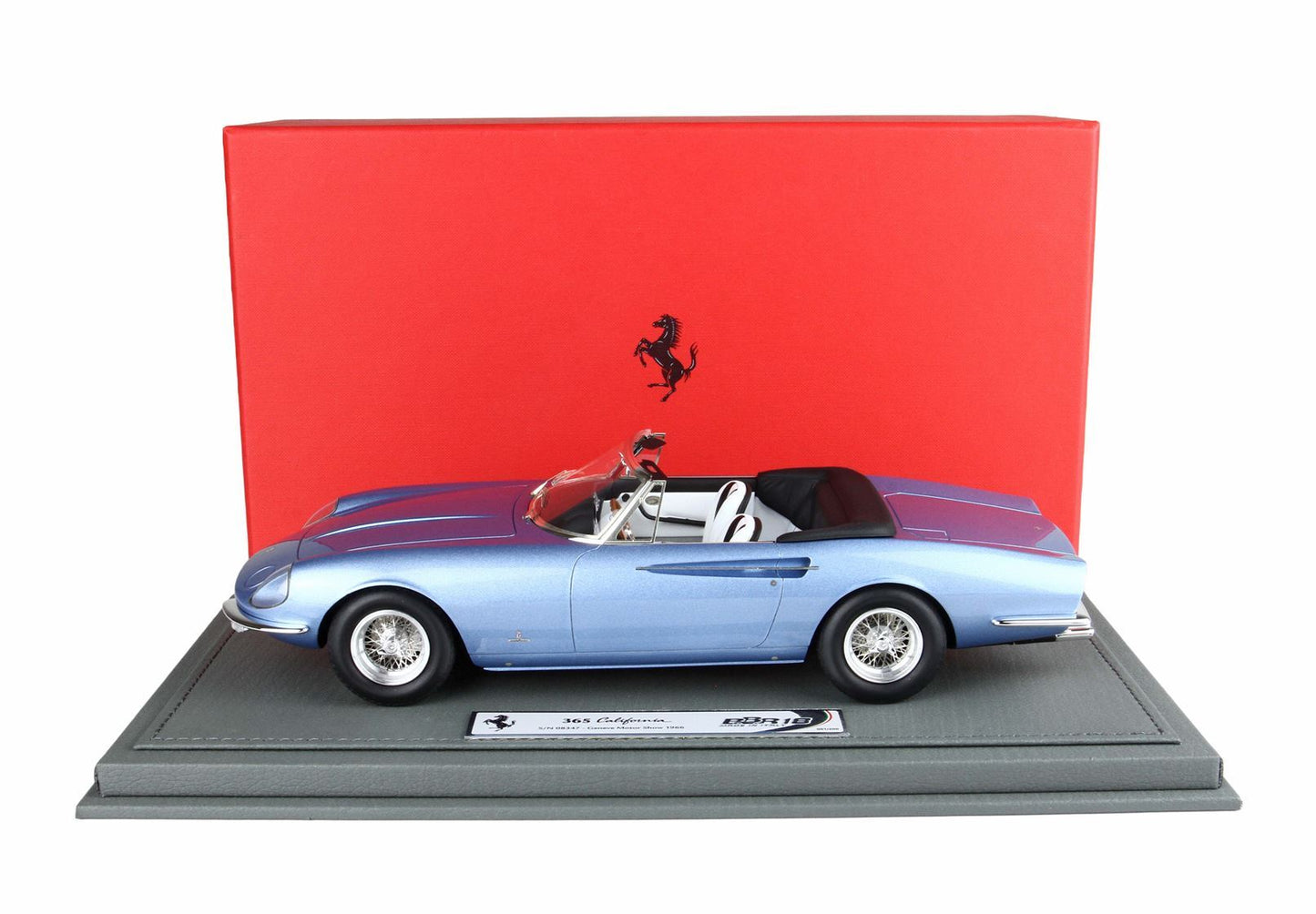 Blue Ferrari 365 California convertible model car displayed on gray base with red Ferrari backdrop, available on Vroomi