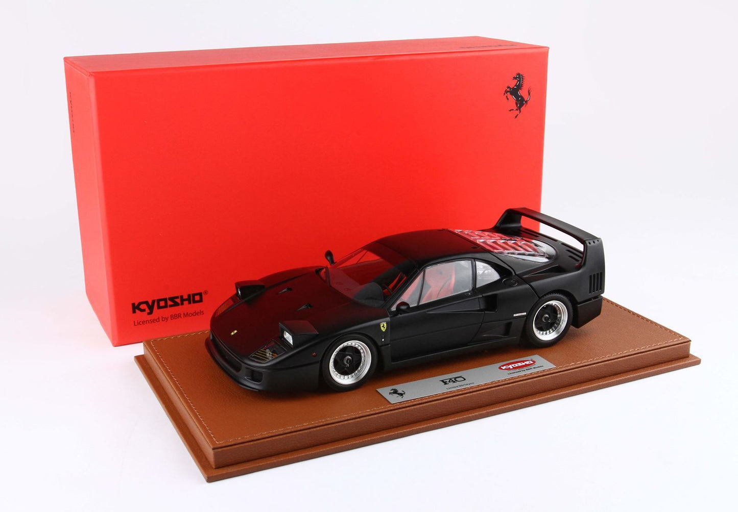 Black Ferrari F40 scale model on brown base with red Kyosho box, available via Vroomi