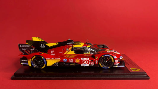 Vista laterale di un modellino di auto da corsa Ferrari 499P rossa e gialla su base nera, disponibile tramite Vroomi.