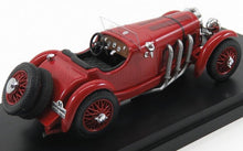 Red vintage racing car model with spare tires and chrome exhaust displayed on a black stand, available on Vroomi