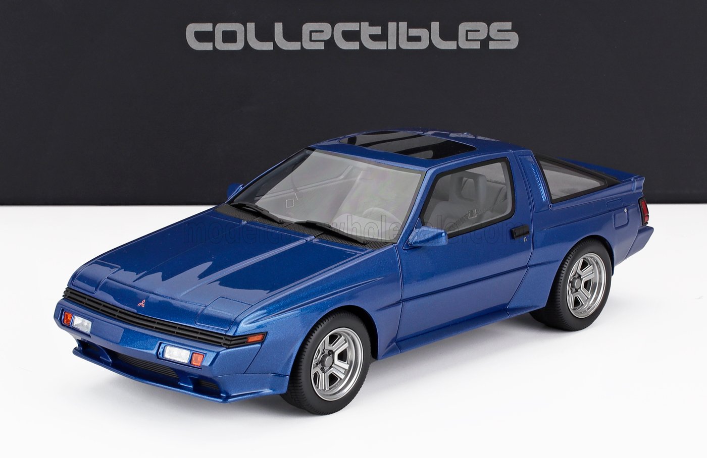 Blue Mitsubishi Starion collectible scale model car on white surface with black background