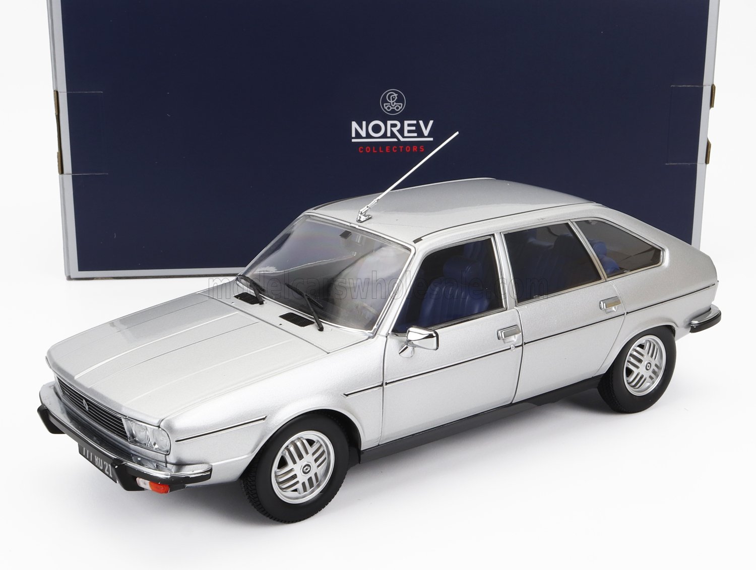 Silver vintage model car with blue interior by Norev Collectors, featured in premium box, available on Vroomi