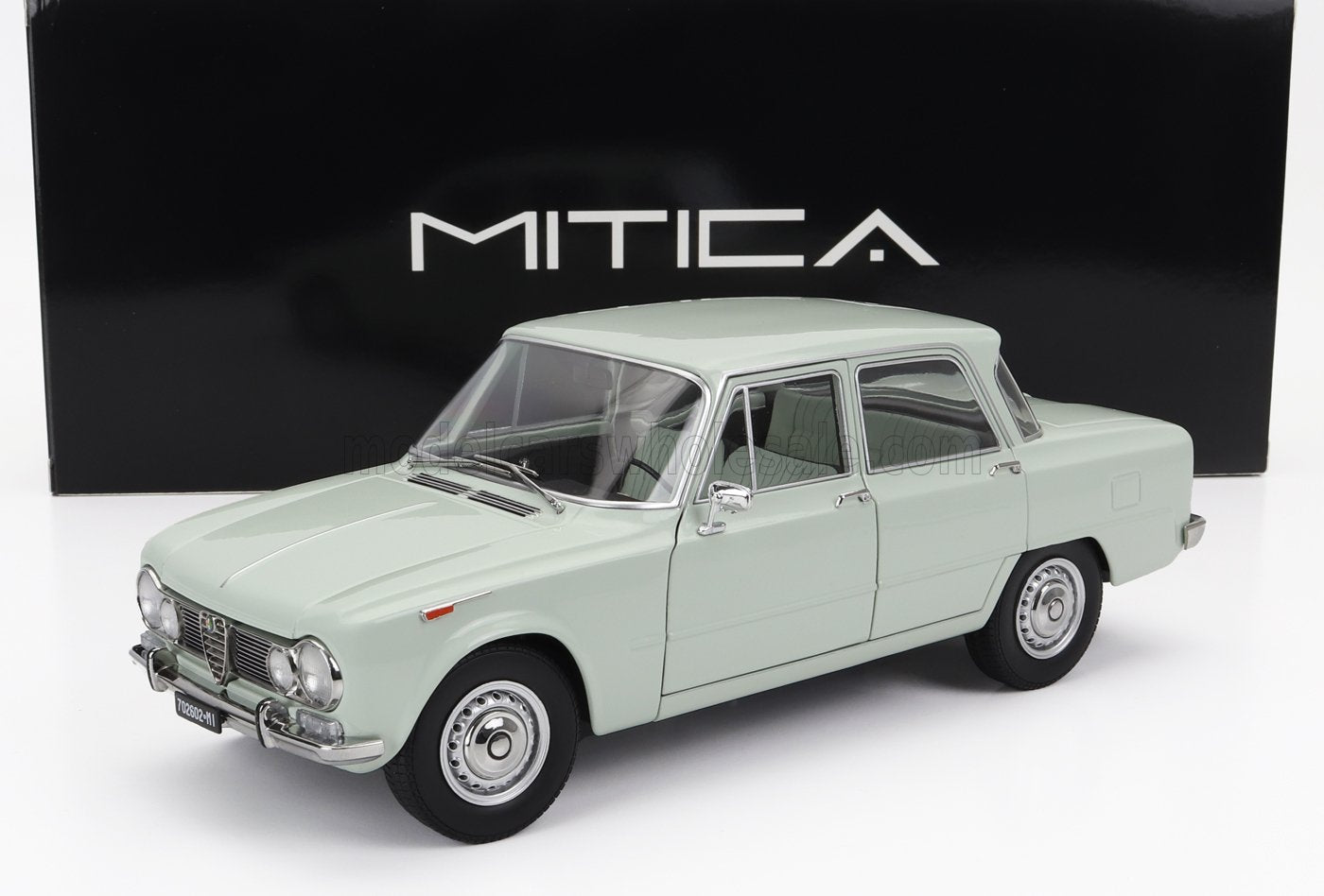 Vintage light green Alfa Romeo Giulia model car in front of black Mitica box, available through Vroomi