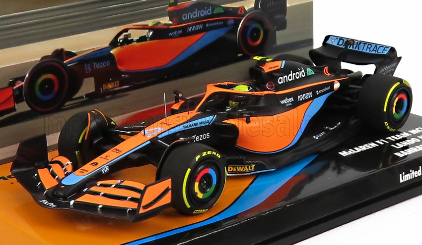 Voiture miniature Formule 1 McLaren en orange et bleu clair, présentée sur socle Vroomi avec décalcomanies sponsors
