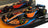 Voiture miniature Formule 1 McLaren en orange et bleu clair, présentée sur socle Vroomi avec décalcomanies sponsors