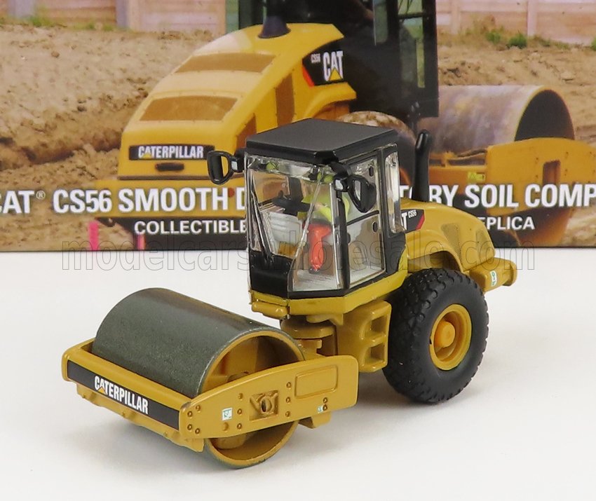 Detailed miniature Caterpillar CS56 soil compactor model on white with packaging, featured on Vroomi platform