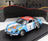 Blue and white scale model car with racing decals, displayed on black base — Vroomi