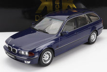 Blue BMW 530d wagon model car with silver rims displayed on white surface, available through Vroomi