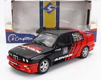 Zwart en rood BMW M3 E30 schaalmodel met Advan-livrei, weergegeven in Vroomi-verpakking.
