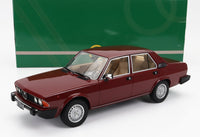 Maquette d'Alfa Romeo bordeaux avec intérieur beige, exposée devant une boîte verte — Vroomi