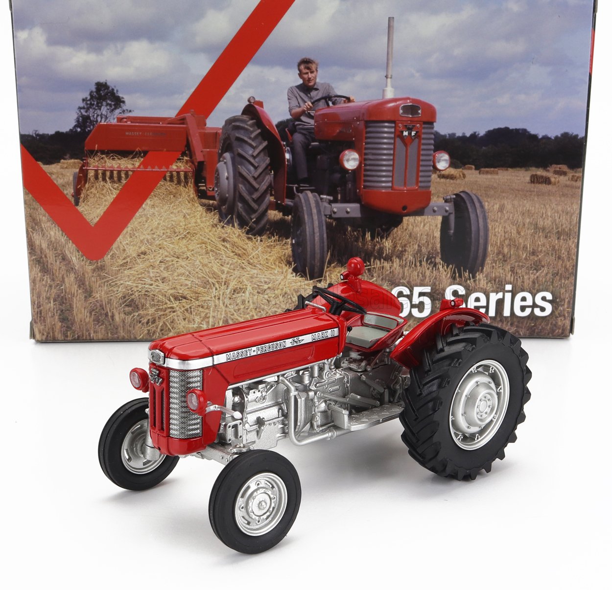 Scale model of red Massey Ferguson 65 Mark II tractor in front of vintage farm scene with real tractor and hay bales, available at Vroomi