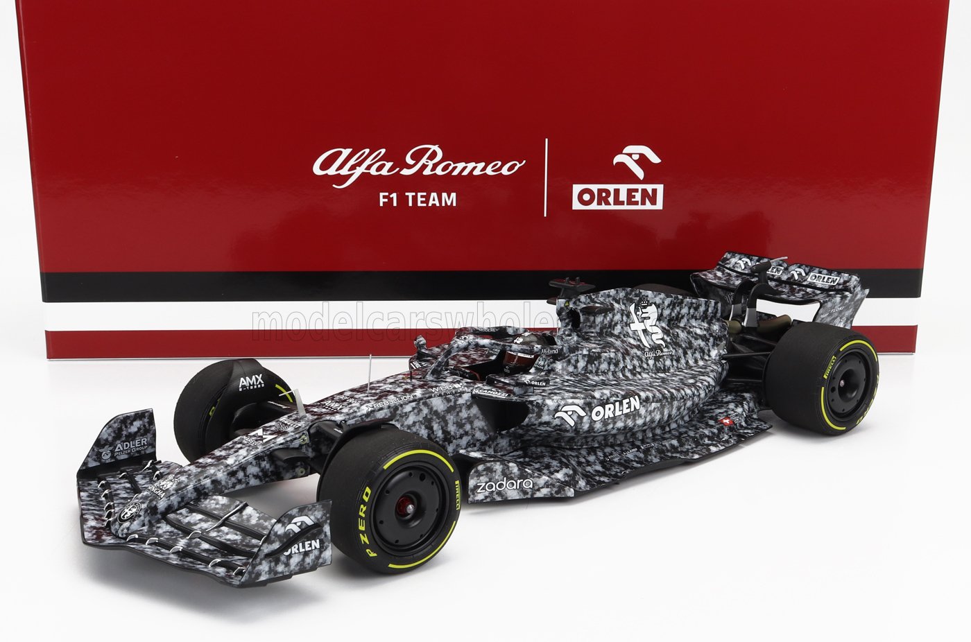 Modellino dell'Alfa Romeo F1 Team con livrea mimetica bianca e nera e marchio Orlen, disponibile su Vroomi.