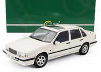 Modellino in scala Volvo 850 GLT color crema con finiture nere, esposto davanti alla scatola verde — Vroomi