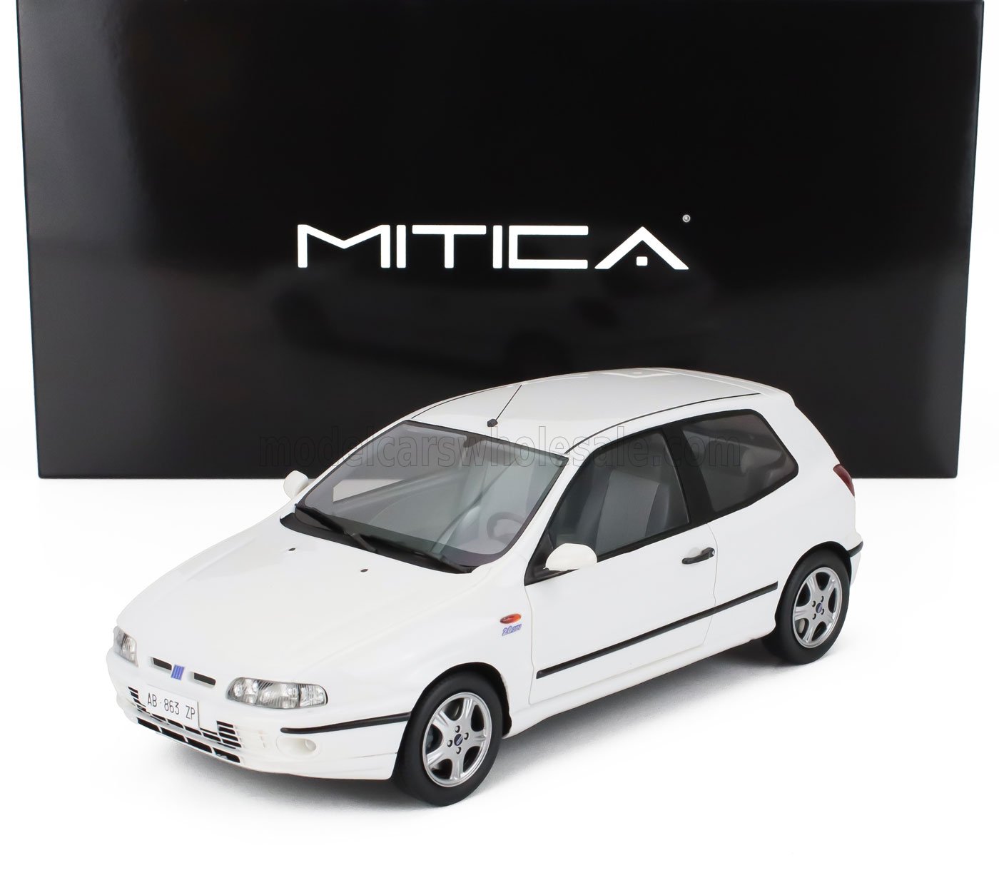 White Fiat model car with black trim displayed in front of black MITICA branded box, now on Vroomi