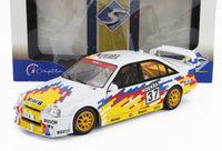 Voiture miniature Opel blanche avec livrée racing colorée, jantes jaunes et marquage DEKRA 37, présentée dans l'emballage Vroomi.