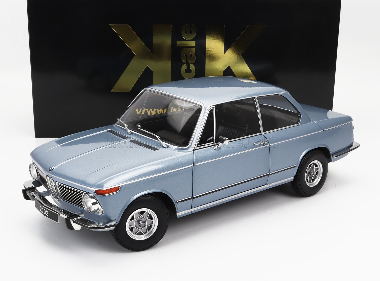 Light blue BMW 2002 model car with black and gold KK scale box, available on Vroomi platform