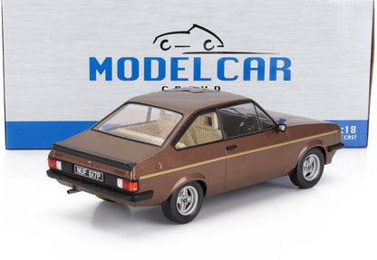 Modellino in scala 1:18 della Ford Escort marrone con striscia gialla, disponibile su Vroomi.