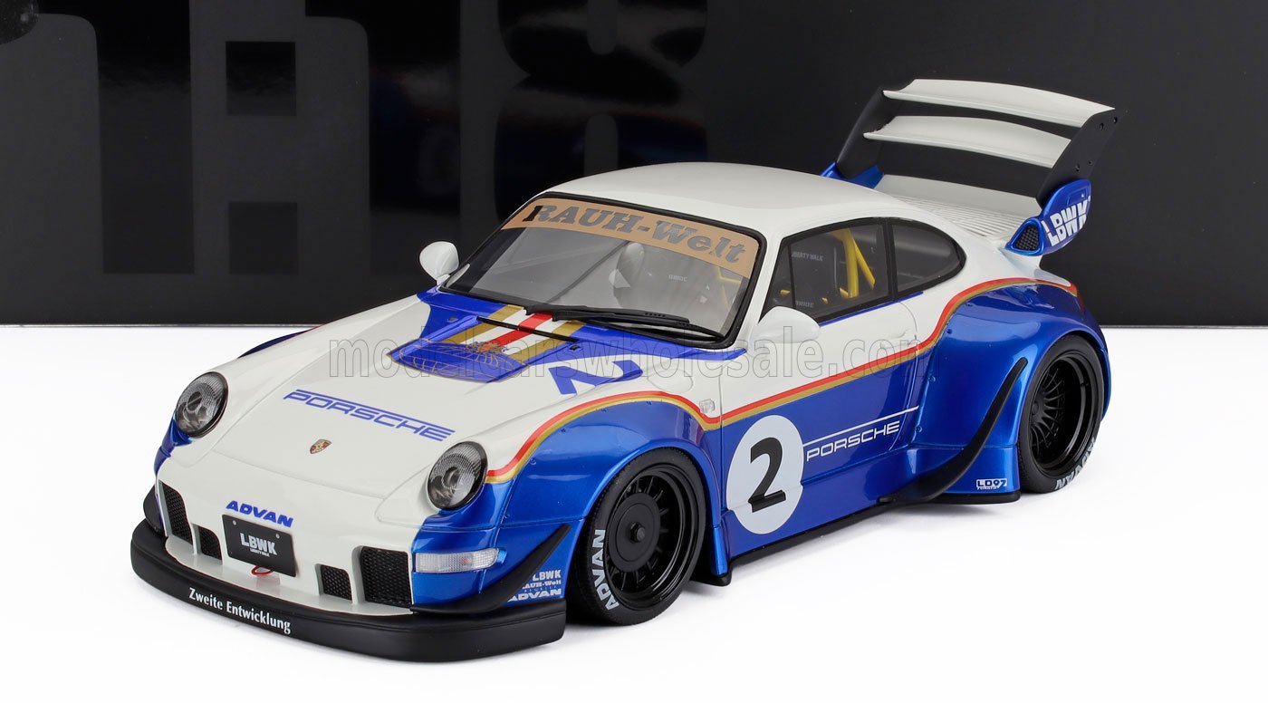 1/18 scale die-cast white and blue Porsche race car model with RAUH-Welt decal, wide body kit, and rear wing available at Vroomi