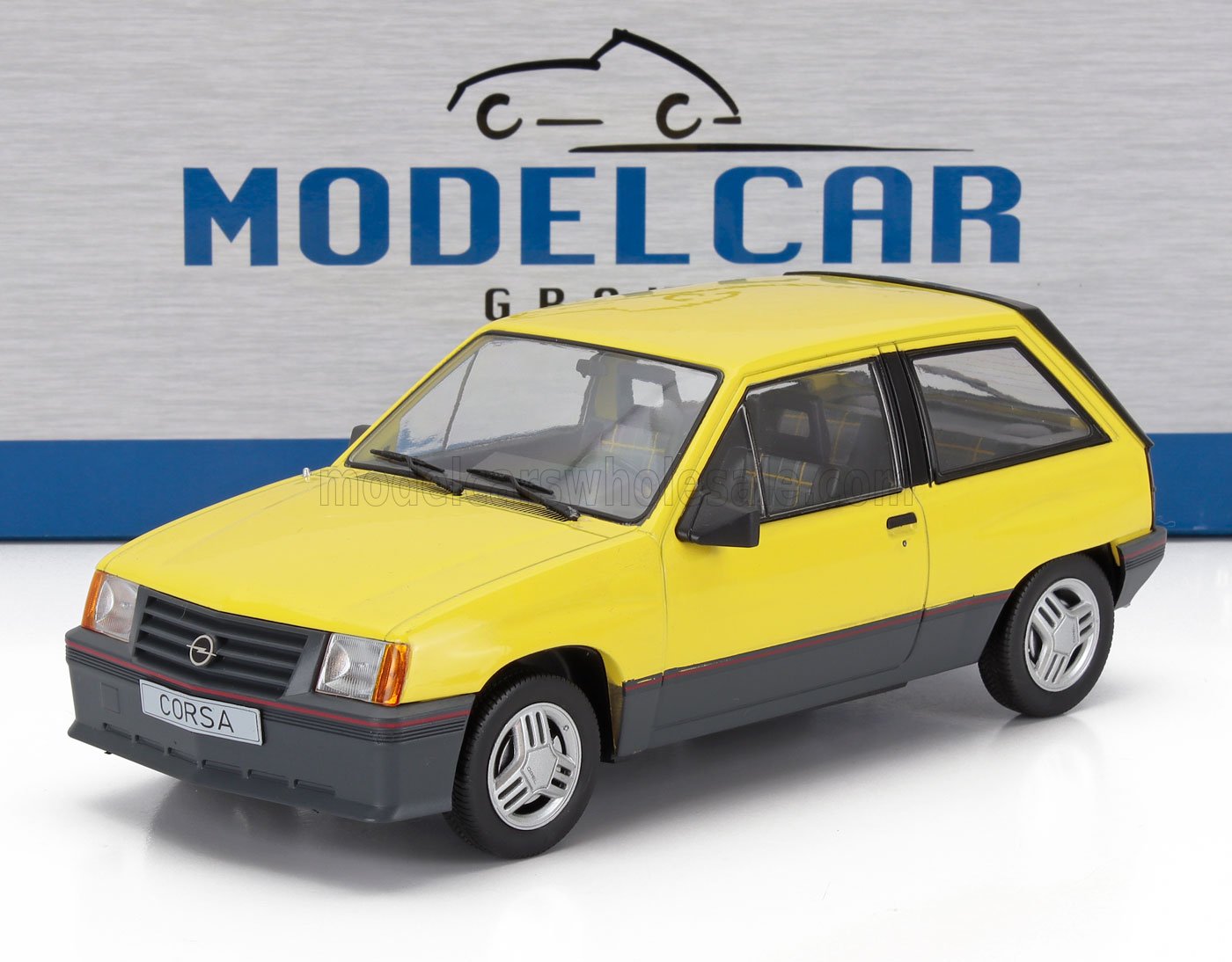 Yellow and gray Opel Corsa scale model car on white surface with Model Car Group logo in background, available at Vroomi