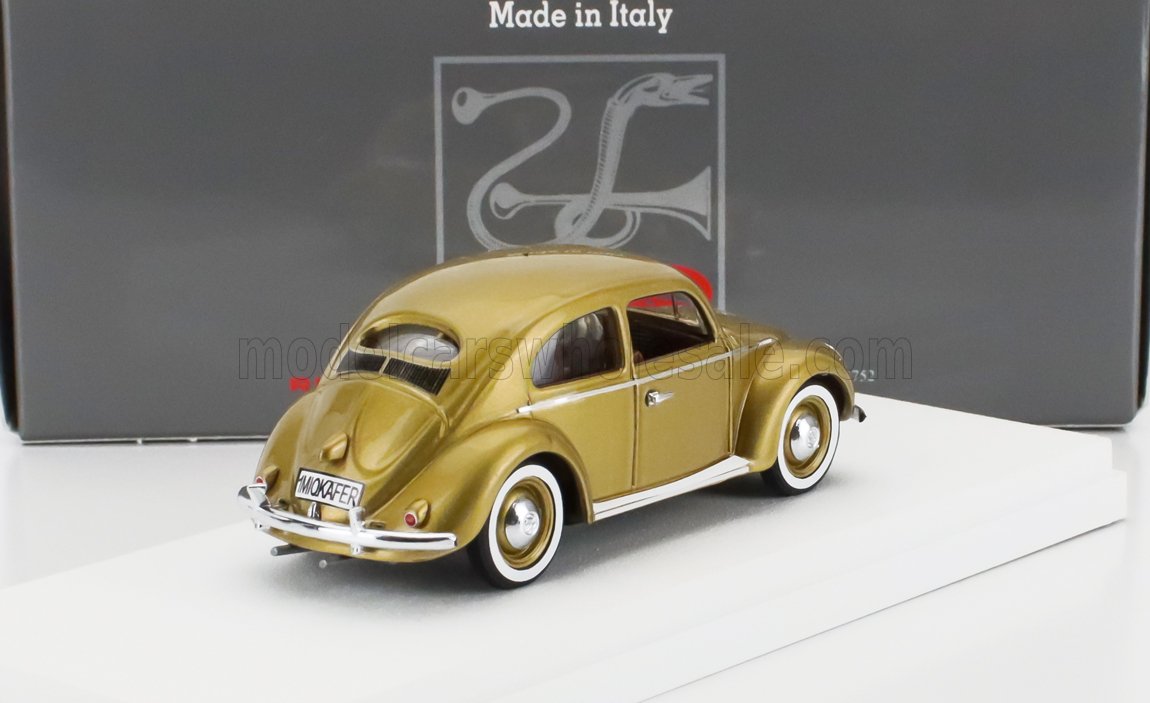 Gold vintage Volkswagen Beetle model car on white stand with black 'Made in Italy' box, sold via Vroomi