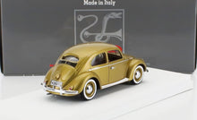 Gold vintage Volkswagen Beetle model car on white stand with black 'Made in Italy' box, sold via Vroomi