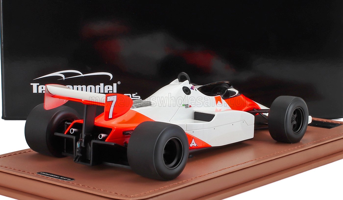 White and red vintage Formula 1 race car model on display with black background, available on Vroomi