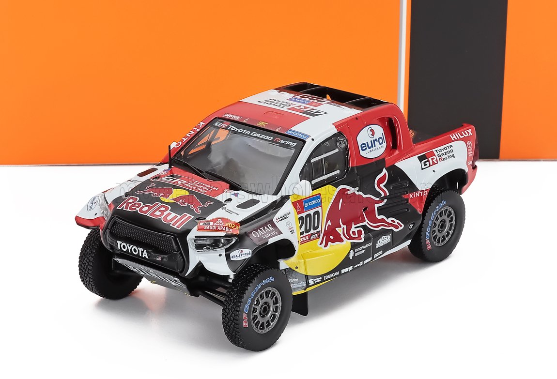 Voiture miniature Toyota Hilux Red Bull Rallye par Vroomi, avec décalcomanies de course et finition à l'échelle 1:18.