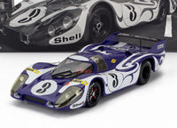 Paars en wit Porsche 917K schaalmodel met Shell livrei, gepresenteerd door Vroomi voor verzamelaars.