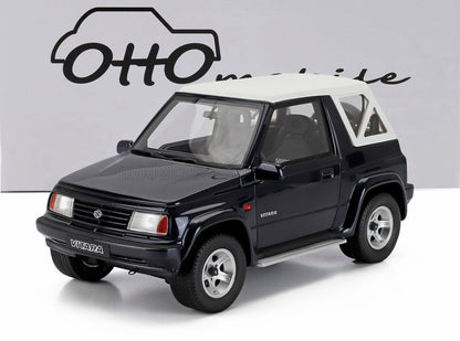 Scale model of black Suzuki Vitara with white roof, displayed against Otto mobile backdrop, on Vroomi