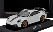 White Porsche GT3 model car with black racing stripe and gold wheels on a display stand available at Vroomi