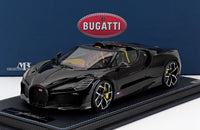 Coche a escala Bugatti Mistral W16 negro con detalles en amarillo, expuesto sobre peana de fibra de carbono por Vroomi