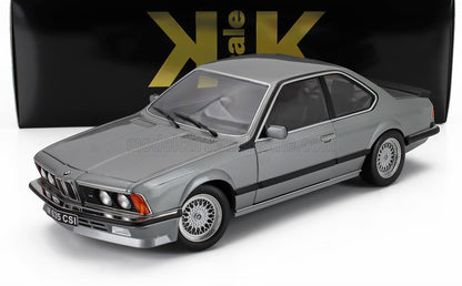 Gray BMW 635 CSi model car with mesh wheels, displayed in front of black and gold packaging, available via Vroomi