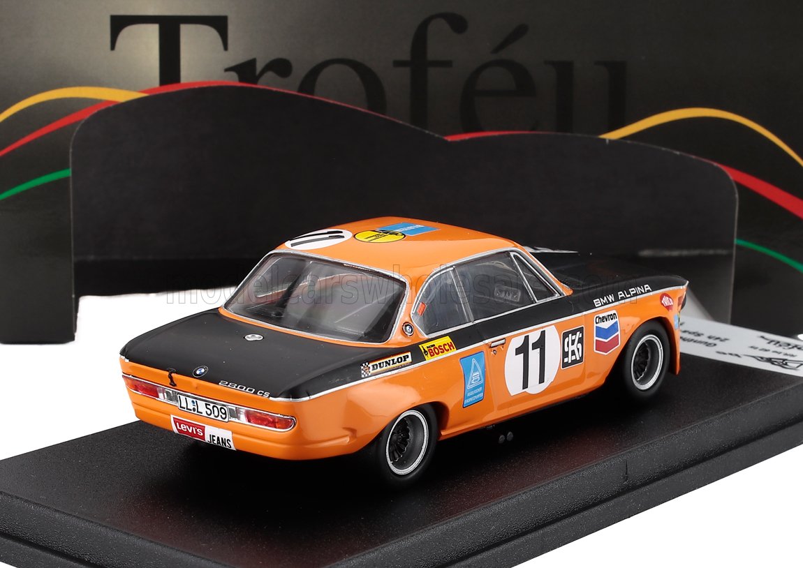 Orange and black BMW Alpina 2000 CS scale model car with race decals, displayed on stand at Vroomi