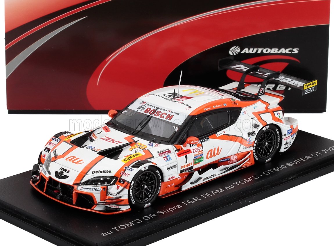 1/43 scale model of au TOM'S GR Supra TGR TEAM GT500 Super GT 2022 in white and orange with sponsor logos on display at Vroomi
