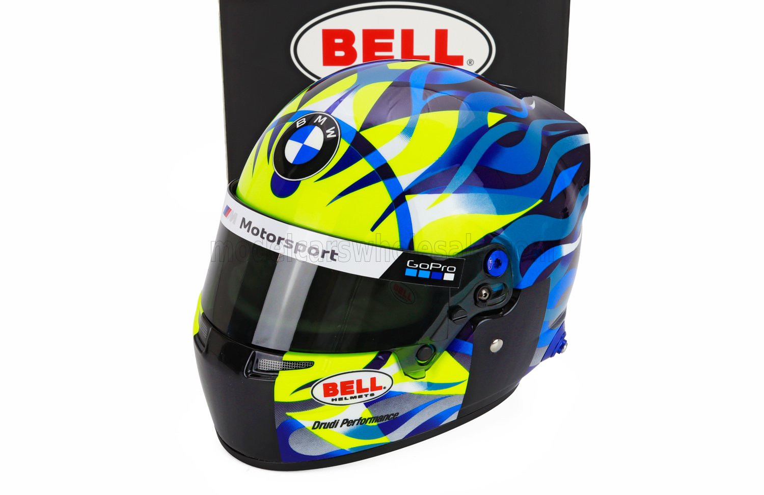 BMW Motorsport scale model car helmet by Bell, featuring GoPro and Drudi Performance logos, displayed at Vroomi