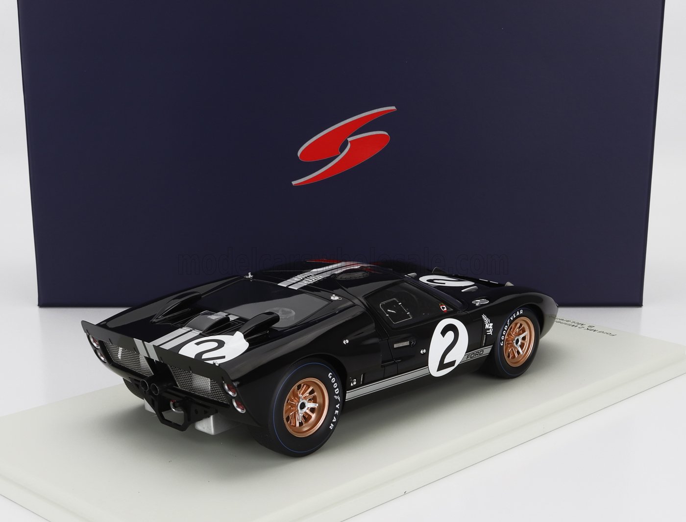 Modellino di Ford GT40 nero con strisce bianche da corsa e numero 2, cerchi in bronzo, esposto su sfondo blu, disponibile su Vroomi.