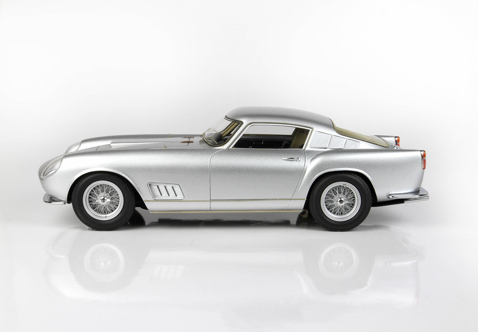 Silver classic vintage sports car side view on white background, available via Vroomi