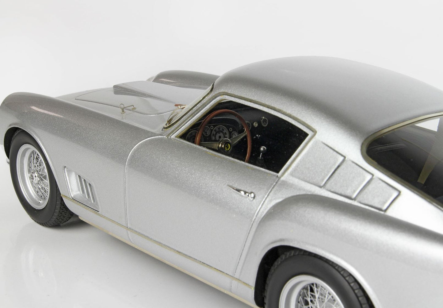 Silver vintage sports car model with wire spoke wheels and detailed interior, available through Vroomi