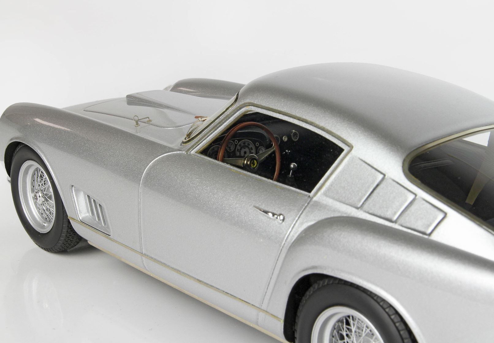 Silver vintage sports car model with wire spoke wheels and detailed interior, available through Vroomi