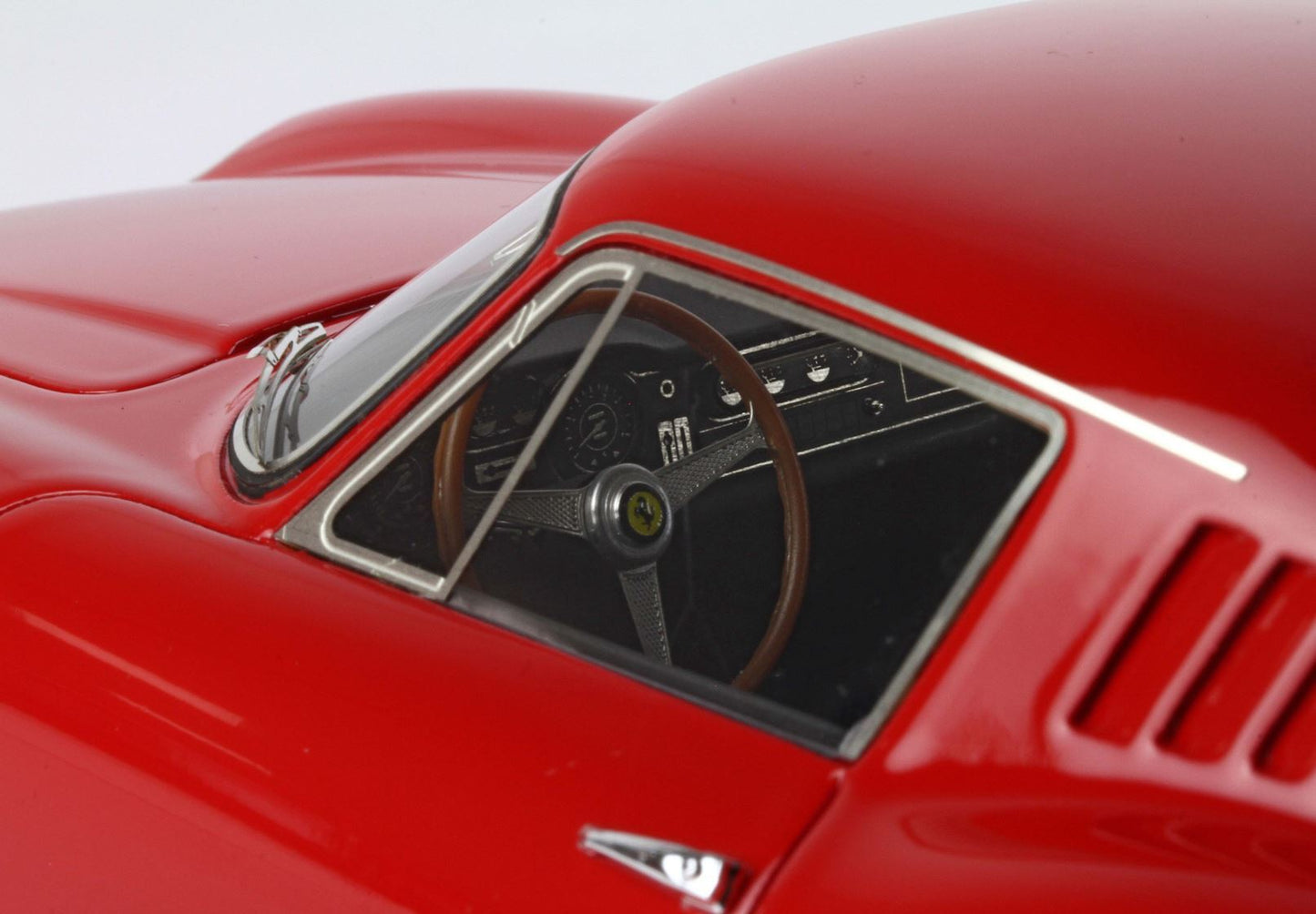 Close-up of red classic sports car interior featuring wooden steering wheel and dashboard, sold on Vroomi