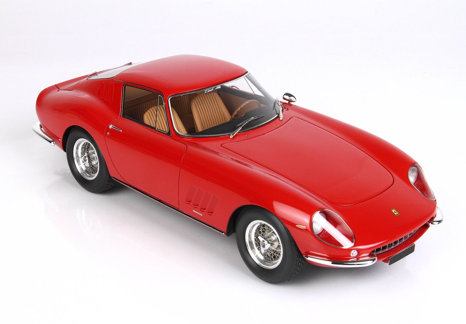 Red vintage sports car model with tan interior and chrome wire wheels, available through Vroomi