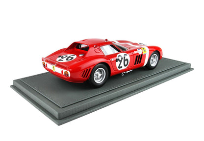 Red vintage Ferrari race car model with number 26 on gray display base, now offered on Vroomi platform