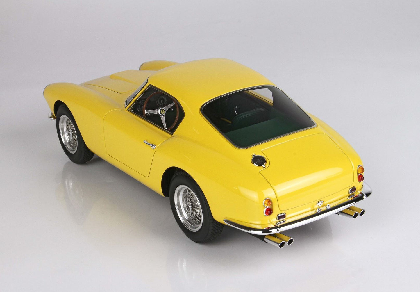 Yellow vintage sports car model with chrome details and wire wheels, offered through Vroomi