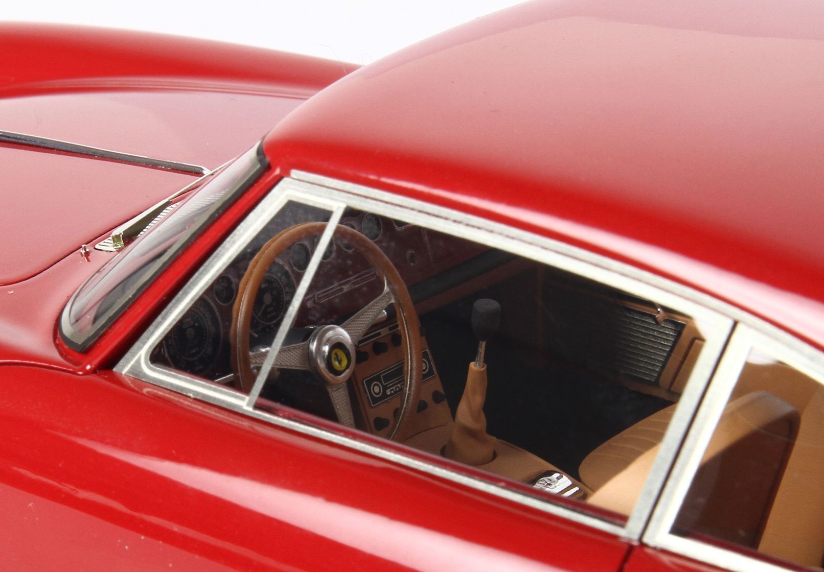 Close-up of a red classic car interior with tan leather seats and wood steering wheel, available on Vroomi
