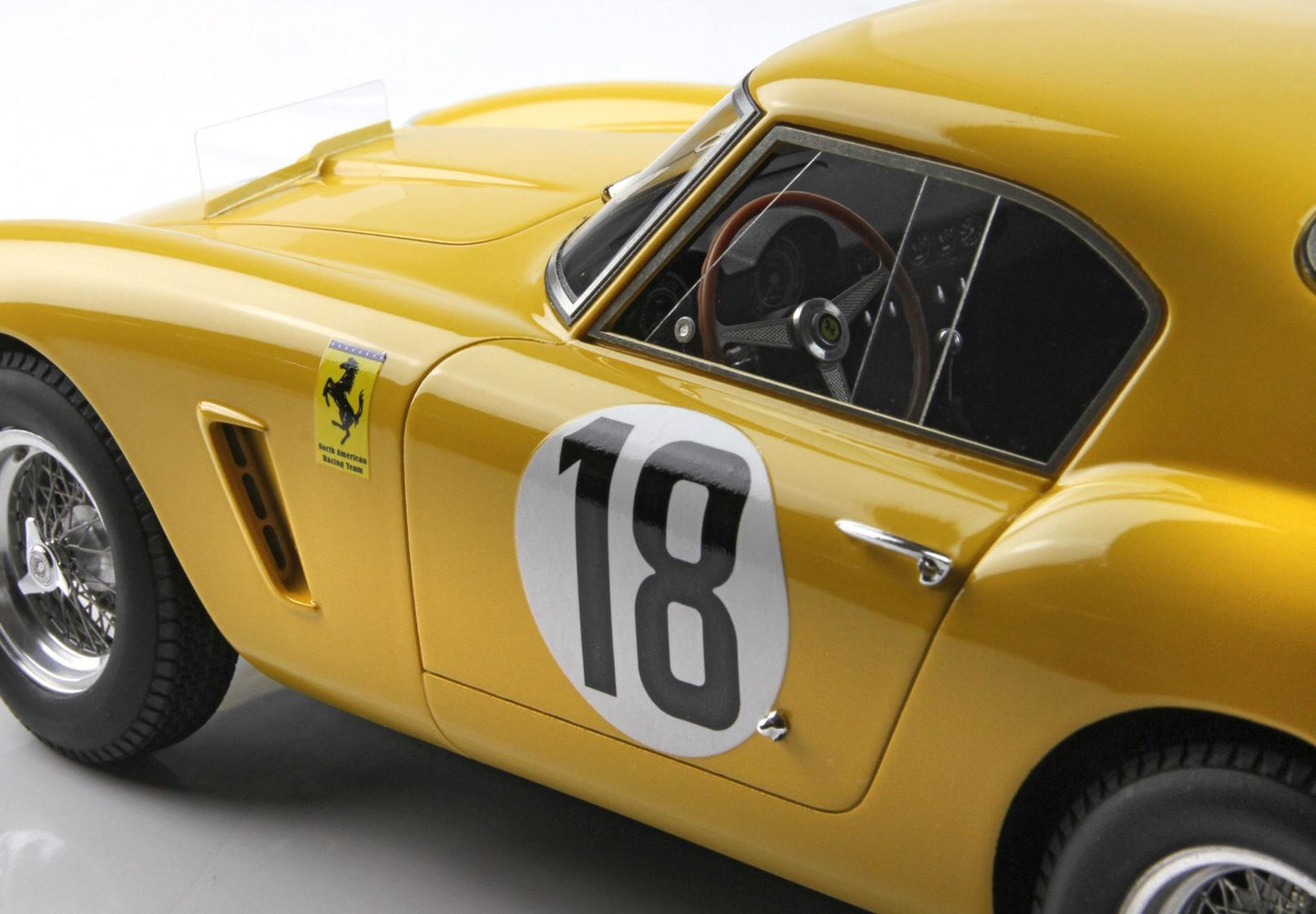 Yellow vintage Ferrari race car model with number 18 decal and North American Racing Team logo, available on Vroomi