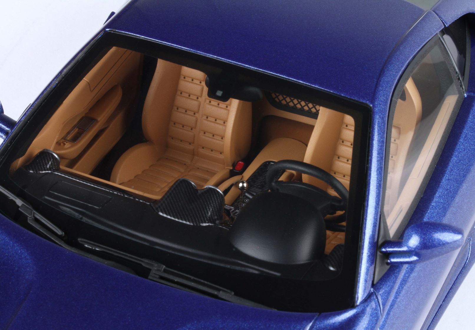 Blue sports car interior with tan leather seats and black steering wheel, available on Vroomi