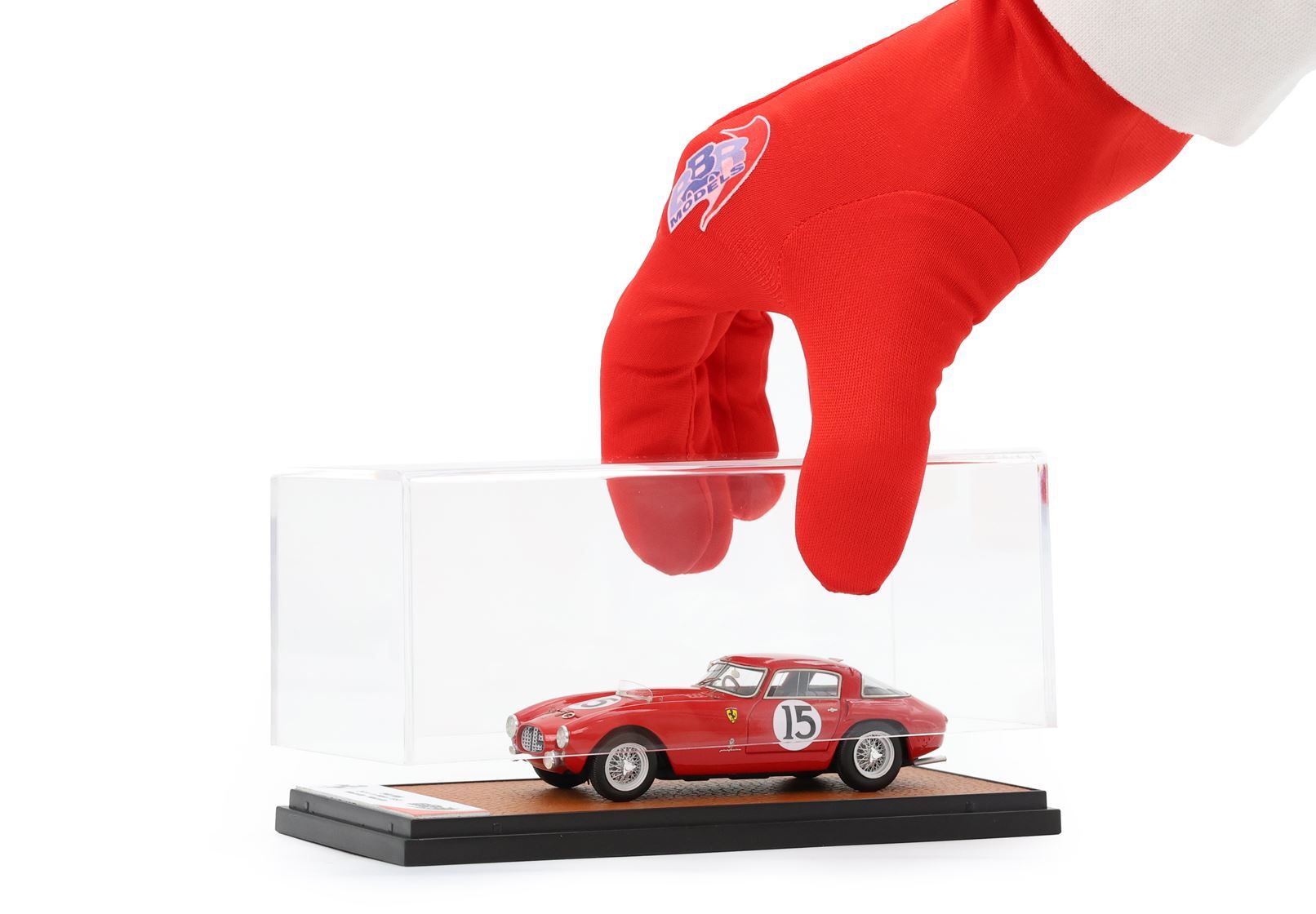Hand in red BBR gloves lifting clear case with red Ferrari model car number 15 on display base, purchasable on Vroomi