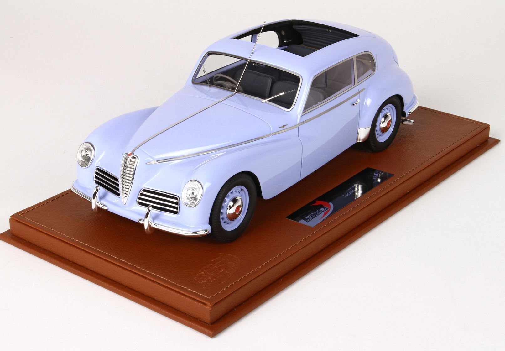 Light blue classic model car displayed on brown leather base, offered through Vroomi platform