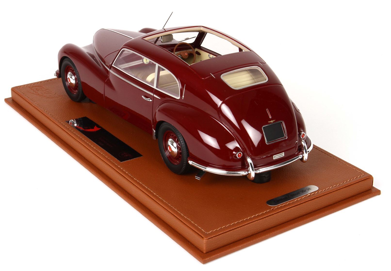 Maroon vintage model car displayed on a tan leather base with plaque, sold on Vroomi