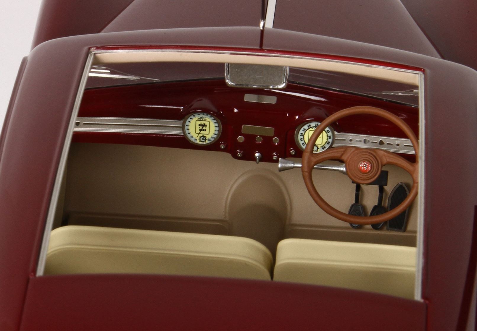 Vintage car interior with red dashboard, tan seats, wooden steering wheel; available on Vroomi